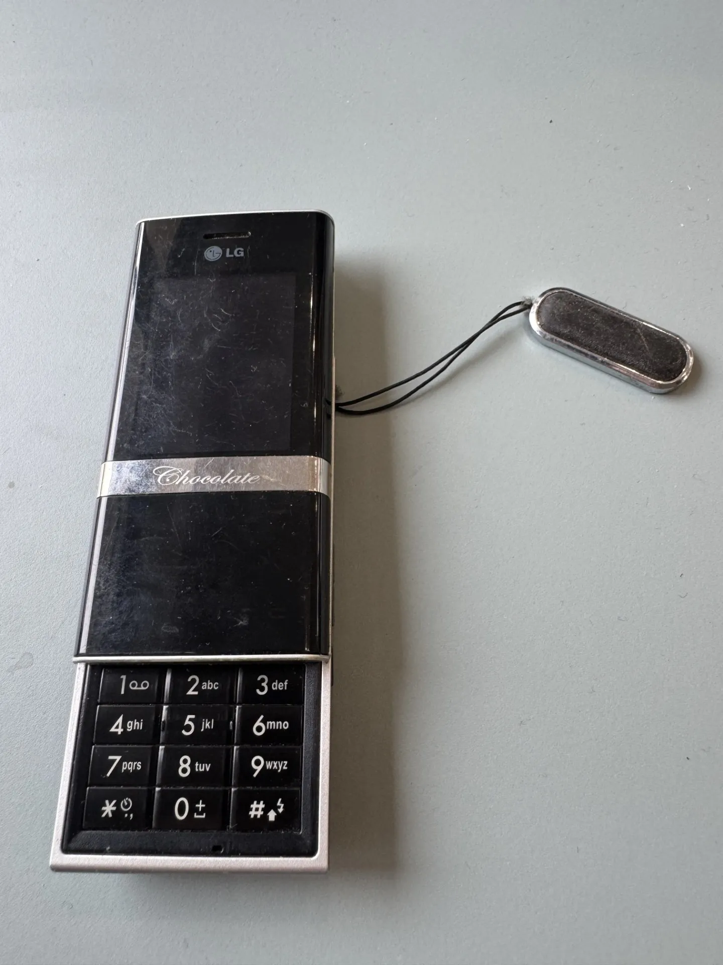 LG Chocolate slīdošais telefons (melns) ar siksniņu